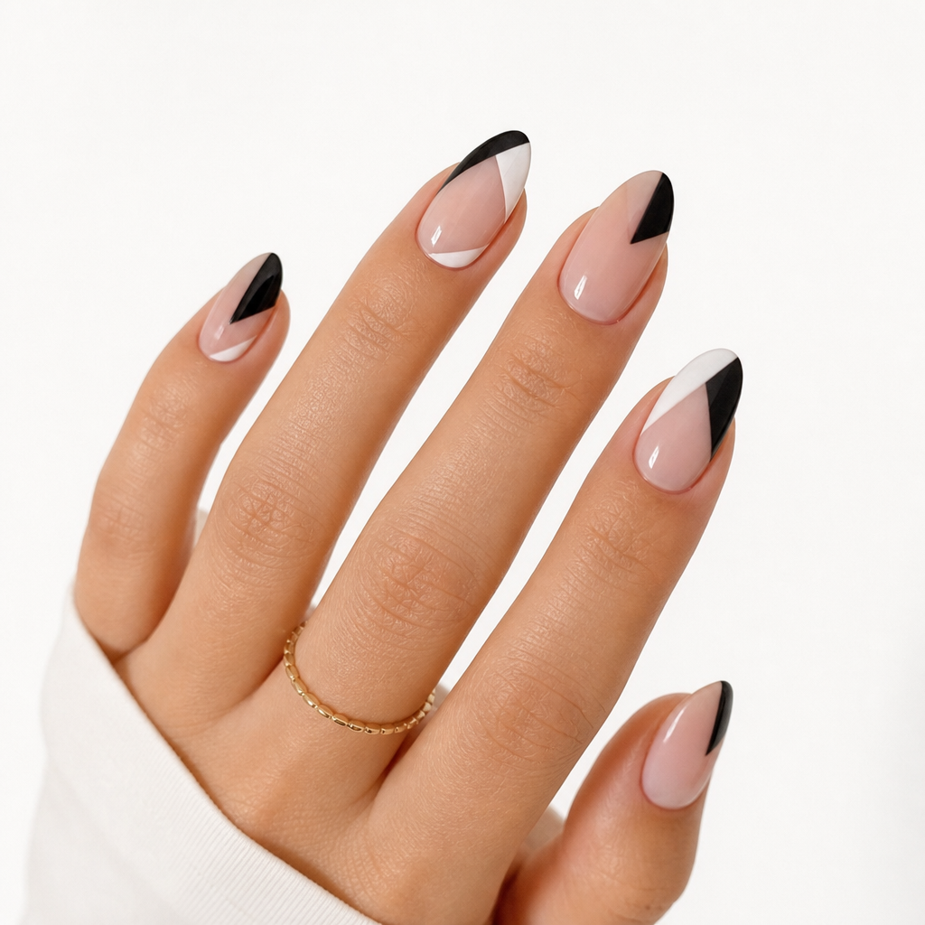 A beautifully manicured hand showing an almond nail shape with a modern geometric negative space design on a clean white background