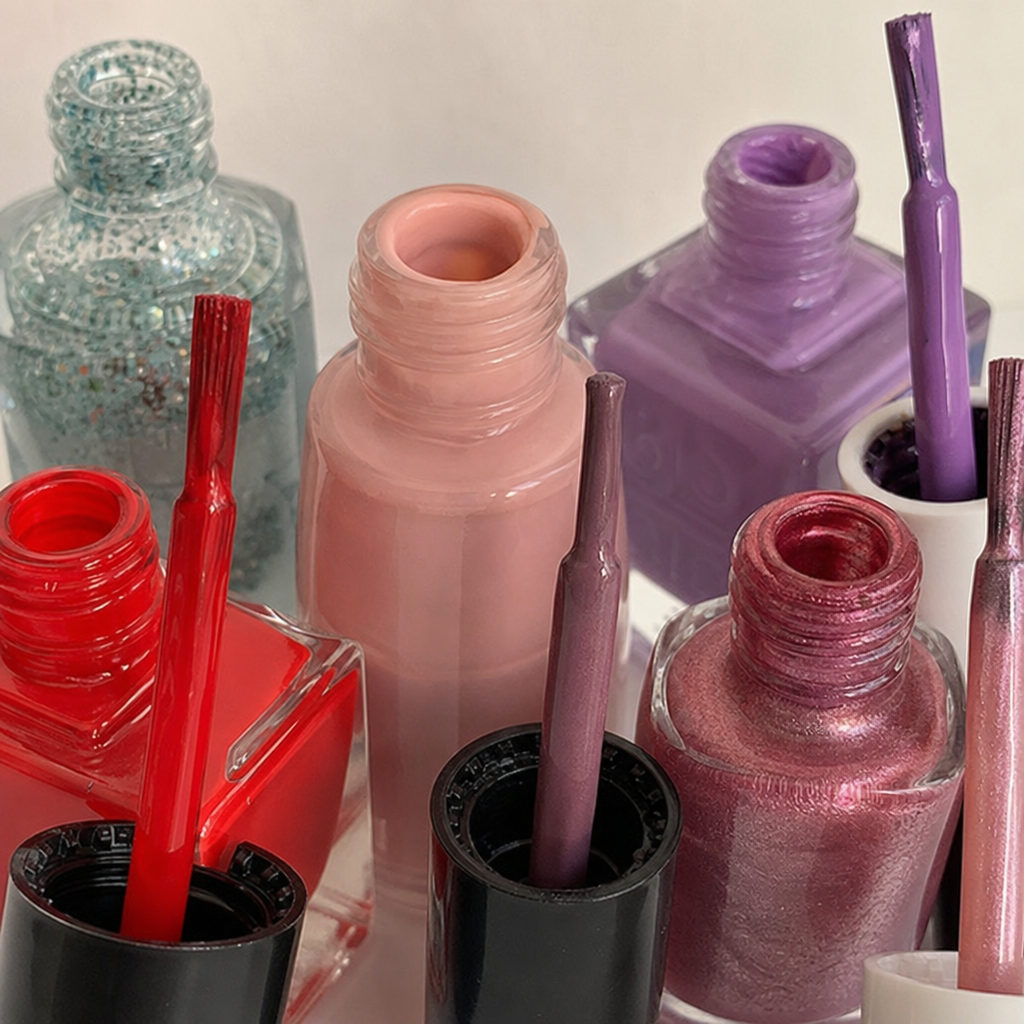 Close up of different types of nail polish bottles and brushes